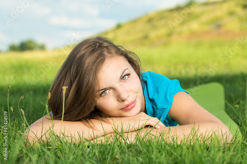 Photo: Young female relaxing in the grass Young female relaxing in the grass
