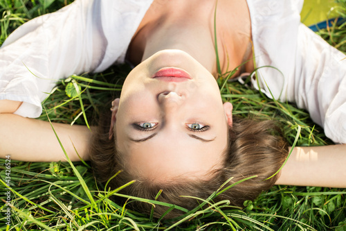 Photo: Young female relaxing in the grass Young female relaxing in the grass