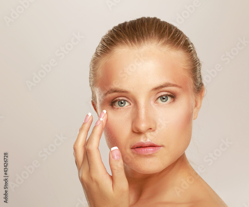 Photo: Happy woman touching her face isolated on whire background Happy woman touching her face isolated on whire background
