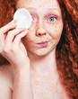 Foto: Make up removal concept, freckled girl with cotton pad Make up removal concept, freckled girl with cotton pad