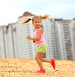 Foto: Little girl running in sand Little girl running in sand
