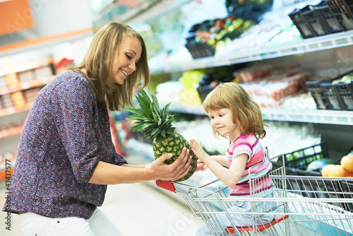 Photo: woman and little girl shopping fruits woman and little girl shopping fruits