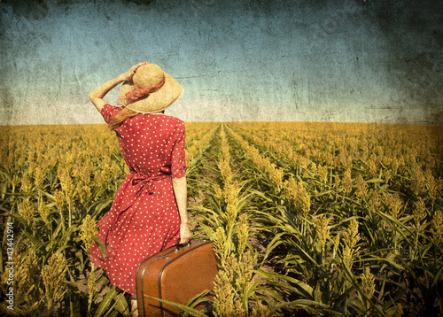 Photo: Redhead girl with suitcase at corn field. Redhead girl with suitcase at corn field.
