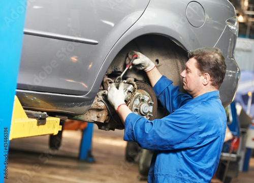 Foto: auto mechanic at car suspension repair work auto mechanic at car suspension repair work
