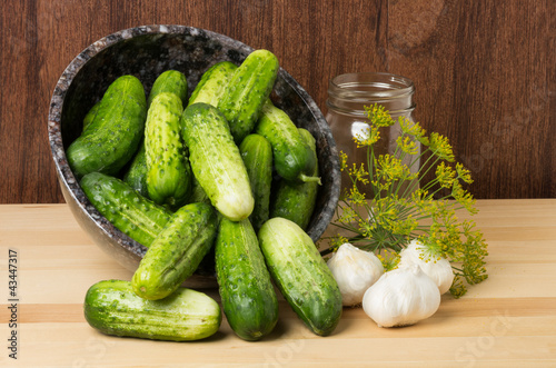 Photo: Bowl of pickles with jar and garlic Bowl of pickles with jar and garlic