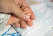 newborn baby hand on a male hand