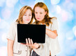 Photo: Two young businesswomen working on laptop. Two young businesswomen working on laptop.