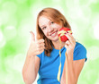 Portrait of a young sport woman holding apple and measuring tape