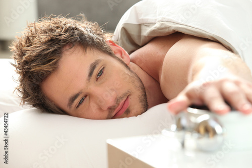 Photo: Man turning off alarm clock Man turning off alarm clock