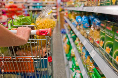 Photo: Frau mit Einkaufswagen im Supermarkt Frau mit Einkaufswagen im Supermarkt