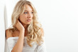 Photo: beautiful blonde woman near white wall beautiful blonde woman near white wall