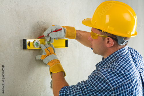 Foto: worker with construction level and pencil worker with construction level and pencil