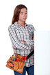 Unhappy woman standing behind a blank sign