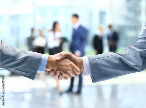 Photo: Business handshake and business people Business handshake and business people