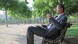 Video: Young happy businessman relaxing on bench in the park Young happy businessman relaxing on bench in the park