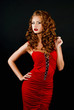 Photo: Beautiful, daring red-haired girl in a red dress on a black back Beautiful, daring red-haired girl in a red dress on a black back