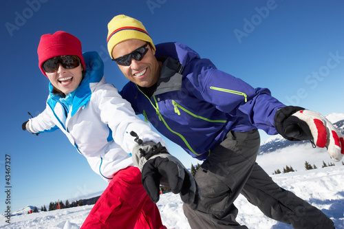 Photo: Couple Having Fun On Ski Holiday In Mountains Couple Having Fun On Ski Holiday In Mountains