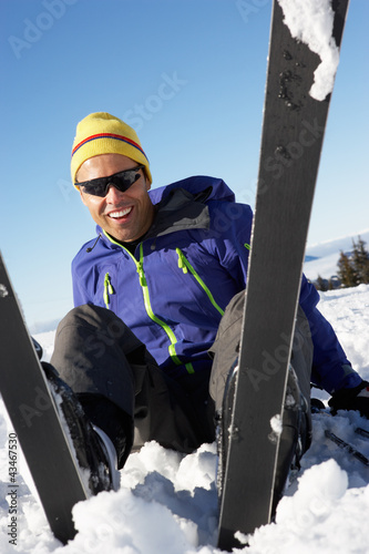 Photo: Male Skier Sitting In Snow With After Fall Male Skier Sitting In Snow With After Fall