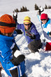 Family Having Snowball Fight On Ski Holiday In Mountains