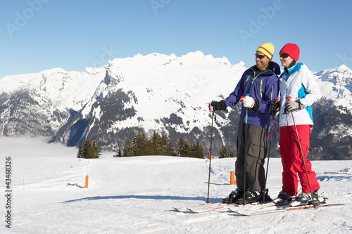 Photo: Couple Having Fun On Ski Holiday In Mountains Couple Having Fun On Ski Holiday In Mountains
