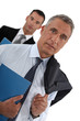 businessman with his assistant trailing behind him