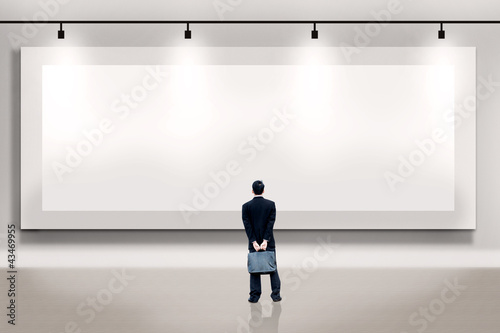 Photo: Businessman looking at an empty billboard Businessman looking at an empty billboard