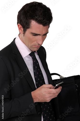 Photo: Bewildered businessman reading a text message Bewildered businessman reading a text message