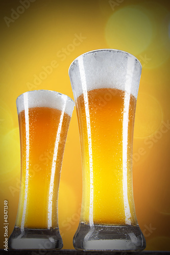 Photo: Beer in a glasses with gold background Beer in a glasses with gold background