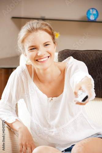 Foto: happy teenage girl with TV remote happy teenage girl with TV remote