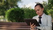 Businesswoman using tablet computer in the park, tracking shot