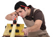 Carpenter planing plank of wood