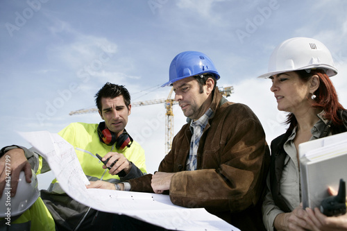 Photo: Construction workers discussing plans Construction workers discussing plans