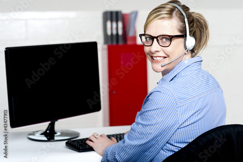 Photo: Portrait of cheerful customer support executive Portrait of cheerful customer support executive