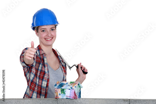 Photo: craftswoman looking a house of bills and making a sign craftswoman looking a house of bills and making a sign