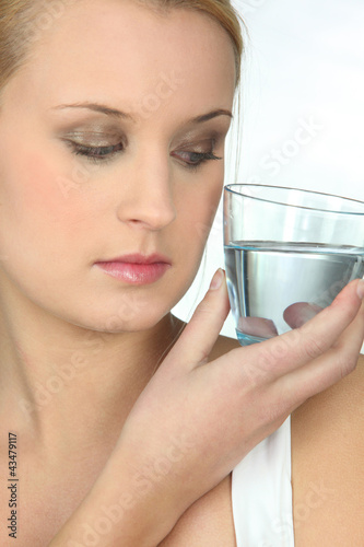 Foto: Woman looking at a glass of water Woman looking at a glass of water