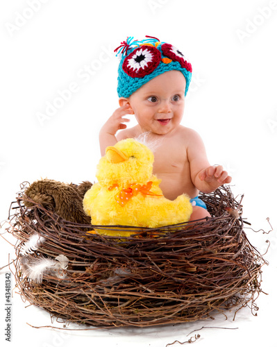 Photo: adorable bébé de 8 mois dans un nid d'oiseau adorable bébé de 8 mois dans un nid d'oiseau