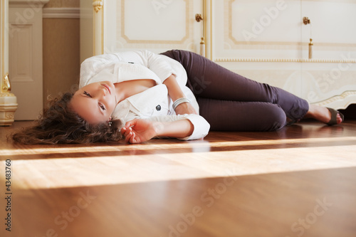 Photo: Beautiful woman lying on the parquet floor Beautiful woman lying on the parquet floor
