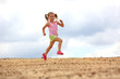Foto: Little girl running in sand Little girl running in sand