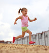 Little girl running in sand