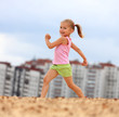Foto: Little girl running in sand Little girl running in sand
