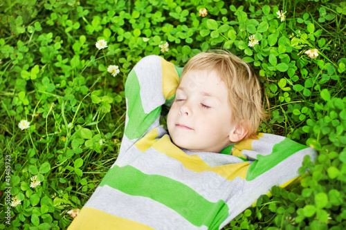 Photo: Little child sleeping in outdoors on grass Little child sleeping in outdoors on grass