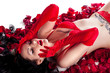 girl with tattoos in red lingerie in the petals of red roses