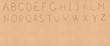 Handwriting English alphabet on flat sand with empty space appro