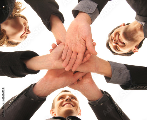 Photo: Three young business persons in a group handshake Three young business persons in a group handshake