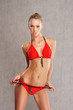 A young blond Caucasian woman posing in a red swimsuit