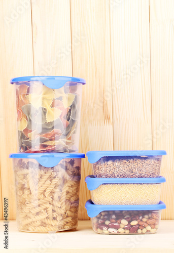 Photo: Filled plastic containers on wooden background Filled plastic containers on wooden background