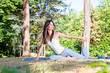 Beautiful woman doing  joga exercising on the grass in forest