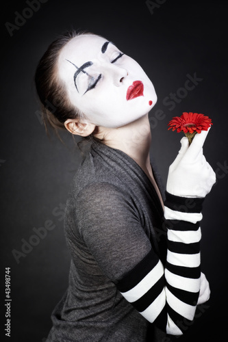 Photo: Dreaming woman mime with red flower Dreaming woman mime with red flower