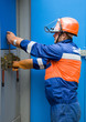 Photo: caucasian electrician working on a panel caucasian electrician working on a panel