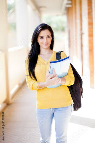 Foto: pretty female university student walking down school corridor pretty female university student walking down school corridor